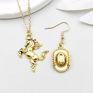 Detail of vintage gold cowboy charms featuring a detailed horse pendant and western hat earring