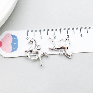 Macro detail of antique silver horse charms on a scale ruler for DIY jewelry making