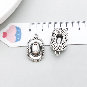 Macro view of vintage silver cowboy hat pendants with intricate rope texture and link ring