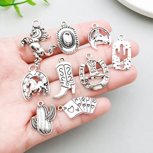 9pcs vintage silver western cowboy charms set held by fingers showing size and detail