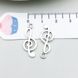 Macro view of antique silver musical note charms with connectors for DIY jewelry making