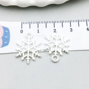 Detalle de colgantes de copos de nieve plateados con regla mostrando 2cm de gala