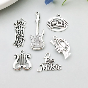 Detail of 6 vintage silver music instrument pendants including guitar and notes