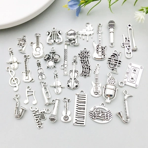 Detailed close-up of vintage silver alloy music instrument charms for DIY jewelry making