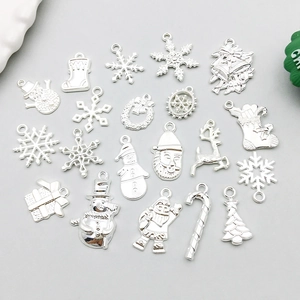 Detalle de dijes navideños plateados con copos y renos para la creación de joyas de DIY