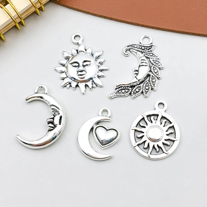Makroaufnahme von Retro-Anhängern aus Legierung für DIY-Schmuck mit Sonnen- und Mondmotiven