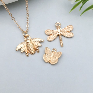 Detail showing gold insect charms with honeybee, dragonfly and butterfly textures