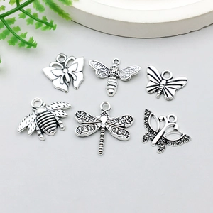 Makro-Detail von sechs antiken Silber-Insektenanhängern für DIY-Schmuck