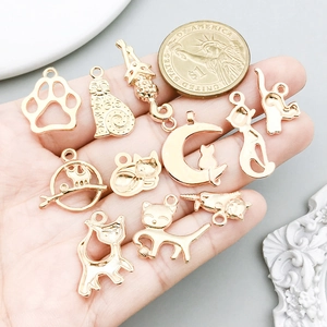 KC gold cat pendants set for DIY jewelry making shown with a coin for size reference