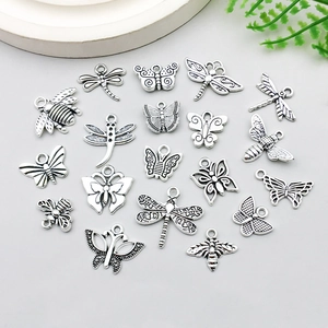 Detail von silbernen Insektenanhängern mit Schmetterlings- und Bienenformen für DIY-Schmuck