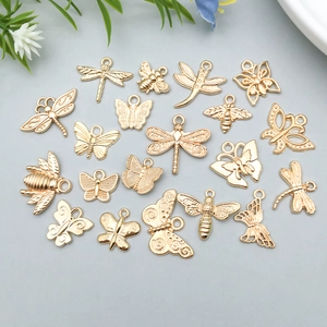 Macro view of gold insect pendants like butterflies and bees for DIY jewelry making