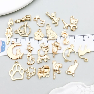 Collection of golden cat and paw alloy pendants for DIY jewelry with scale measurement