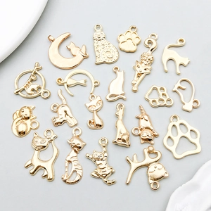 Flat lay of 19 gold-plated cat pendants for DIY jewelry making in various cat shapes