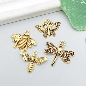 Detailed view of antique gold insect pendants including butterfly, bee, and dragonfly charms