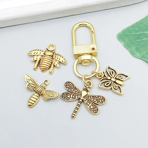 Detailed view of gold alloy dragonfly, bee and butterfly pendants with lobster clasp