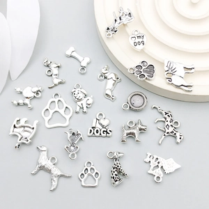 Collection of antique silver dog-themed alloy charms featuring bone and paw prints