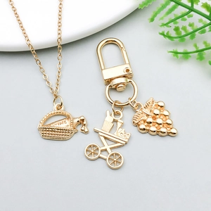 Detail view of gold wine-themed charms including wine bottle cart and grape cluster