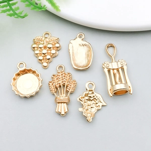 Close-up of golden wine-themed alloy pendants including grapes and bottle openers