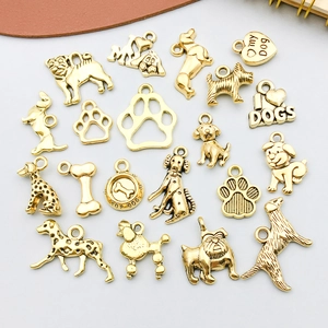 Vue détaillée de divers pendentifs dorés sur le thème des chiens et d'os pour bijoux DIY