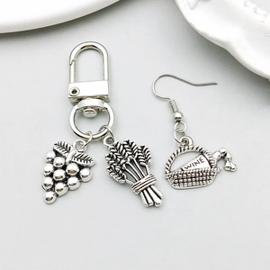 Macro shot of antique silver wine basket earring and grape bundle charm pendant details