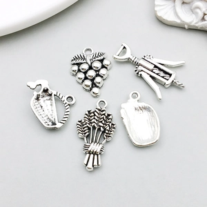 Detailed view of antique silver wine-themed alloy charms with grape and opener shapes