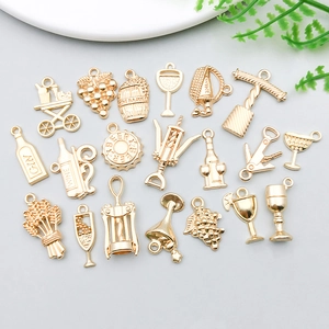 Detailed flat lay of golden wine-themed pendants for DIY jewelry and necklaces