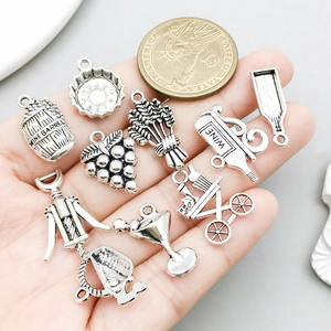 Antique silver wine themed charms set including wine barrel and bottle on hand