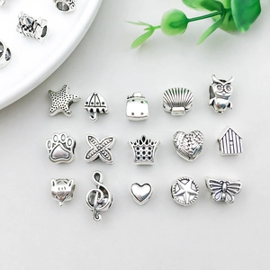 Detailed view of antique silver charms including starfish and crowns for DIY jewelry making