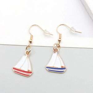Detail of nautical sailboat earrings with colorful oil drip finish and golden hooks