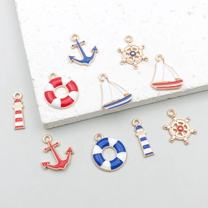 Detail of nautical alloy charms featuring anchors and sailboats in red and blue enamel