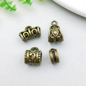 Detailed view of antique bronze alloy pendant connectors with embossed relief textures