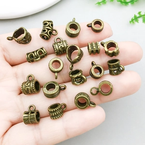 Antique bronze alloy pendant connectors for DIY jewelry making shown on hand