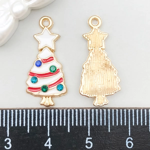Dettaglio di ciondoli albero di Natale in smalto bianco con strass e retro dorato