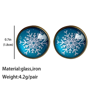 Macro detail of blue snowflake glass stud earrings with size and material labels
