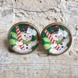 Retro Christmas snowman earrings with bronze frame and glass dome on stone background