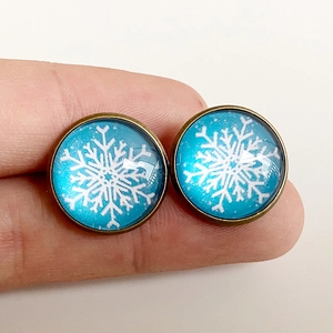 Vintage bronze snowflake earrings with blue glass dome cabochon on white background