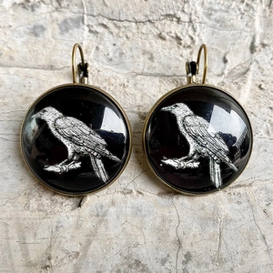 Vintage bronze leverback earrings featuring a white raven pattern under glass cabochon