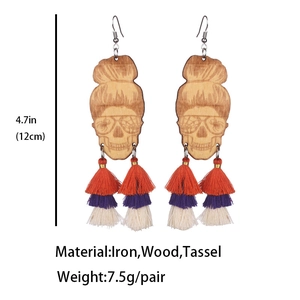 Détail des boucles d'oreilles tête de mort en bois de 12cm avec pompons colorés