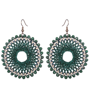 Macro detail of dark green wire-wrapped hoop earrings with shimmering crystal beads