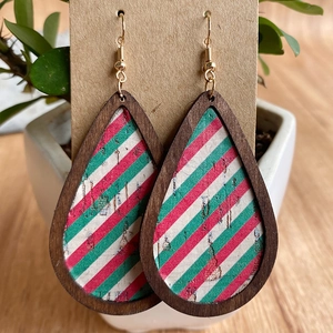 Macro view of teardrop wood earrings with festive red and green stripe pattern and glitter