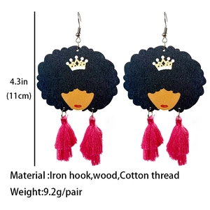 Detail von Holzohrringen mit Afro-Königin und leuchtend pinkfarbenen Quasten