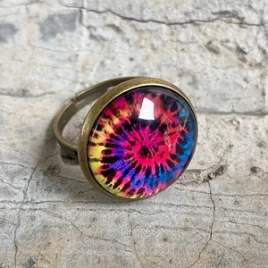 Detail eines verstellbaren Vintage-Rings mit buntem psychedelischem Muster unter Glas