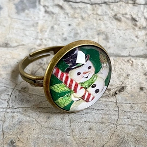 Detailsicht eines Retro-Schneemann-Rings aus Bronze mit Glas-Cabochon-Oberfläche