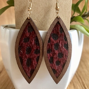 Detalle de pendientes de hoja de madera con estampado de leopardo y ganchos dorados