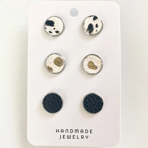 Detail of round stud earring set featuring cow print, leopard faux fur and black leather