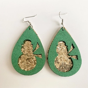 Detail of teardrop faux leather earrings featuring green glitter and snowman cutouts