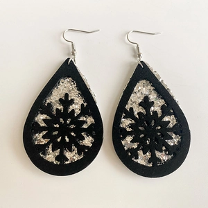 Detail of teardrop earrings with laser-cut snowflake on silver glitter leather