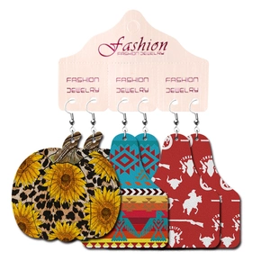 Detail of western earrings set with cow, pumpkin, and turquoise geometric leather patterns