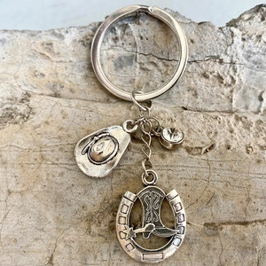 Western cowboy keychain featuring a silver hat, horseshoe, and boot pendants with rhinestone