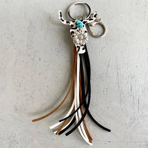 Détail d'un porte-clés bohème en cuir avec crâne de taureau léopard et perles turquoise